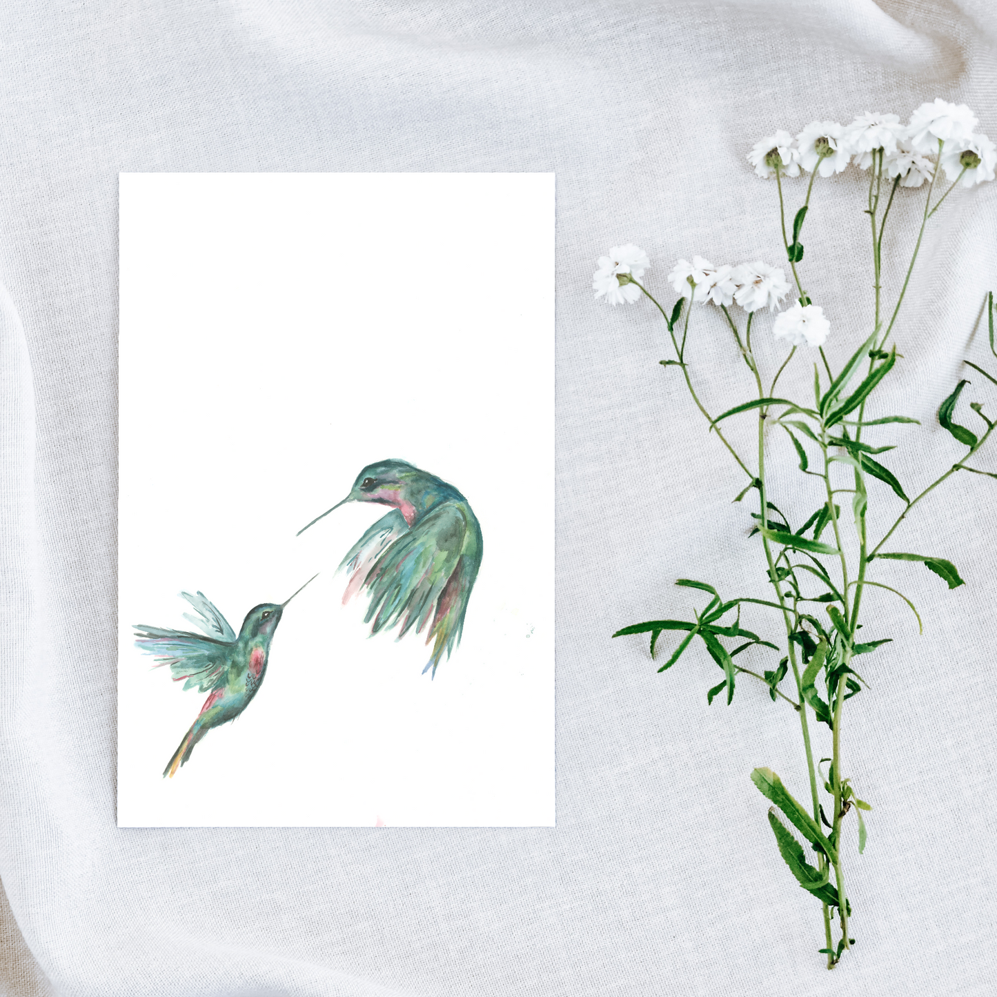 Art print of two hummingbirds next to a branch with white flowers on a textured surface.