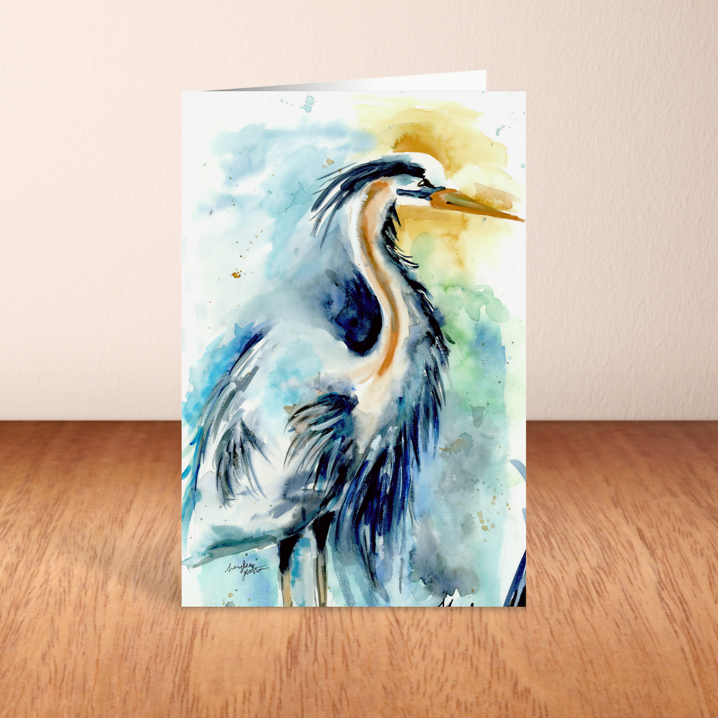 Folding cardstock greeting card featuring original watercolor piece Male Heron standing upright on a wooden table.