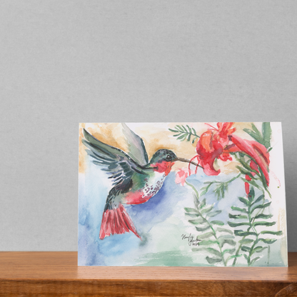 Folding cardstock greeting card featuring original watercolor piece A Garden Visit resting open on a wooden table against a white wall.