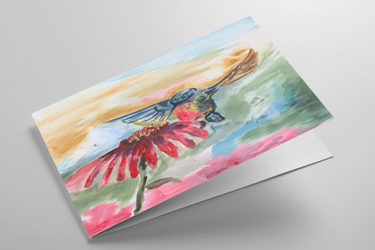 Folding greeting card featuring original watercolor piece A Jeweled Messenger laying down showing cardstock thickness and blank inside.