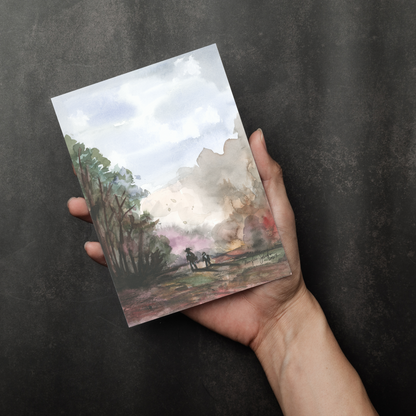 Flat cardstock note card featuring original watercolor piece A Walk in the Forest in a person's right hand. The background transitions from black at the bottom to a dull gray at the top.