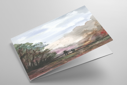 Folding greeting card featuring original watercolor piece A Walk in the Forest laying down showing cardstock thickness and blank inside.