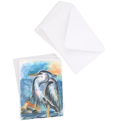 A stack of flat cardstock note cards featuring original watercolor piece Dark Heron next to a stack of the matching euro flap envelopes.