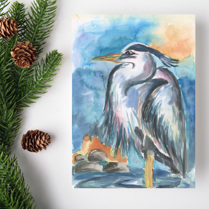 Flat cardstock note card featuring original watercolor piece Dark Heron on a white background. Green pine fronds with brown pinecones decorate the left side.