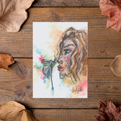 Flat cardstock note card featuring original watercolor piece Dragonfly Girl styled on rustic wooden boards with dried autumn leaves.