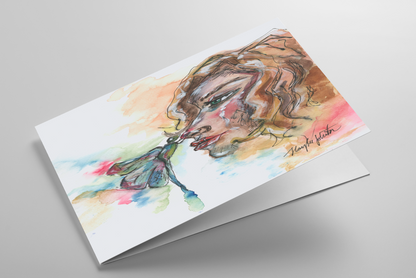 Folding greeting card featuring original watercolor piece Dragonfly Girl laying down showing cardstock thickness and blank inside.