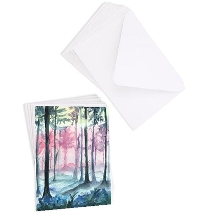 A stack of flat cardstock note cards featuring original watercolor piece Fairy Forest next to a stack of the matching euro flap envelopes.
