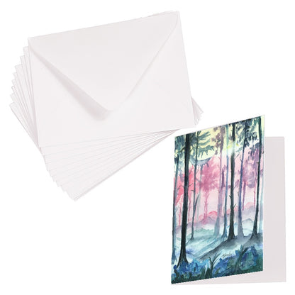 Folding cardstock greeting card featuring original watercolor piece Fairy Forest laying next to a stack of euro flap envelopes.
