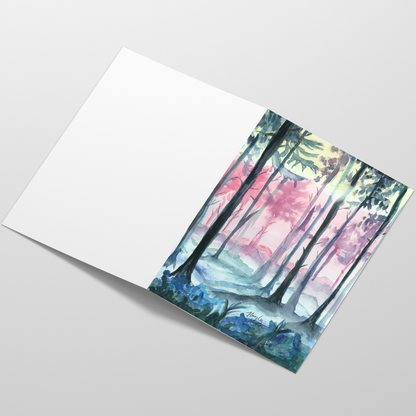 Folding cardstock greeting card featuring original watercolor piece Fairy Forest laying open in a table with the outside facing up.