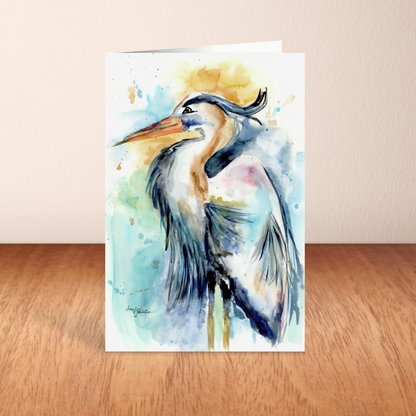 Folding cardstock greeting card featuring original watercolor piece Female Heron standing upright on a wooden table.
