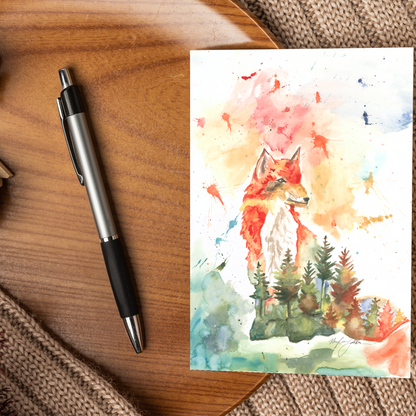 Flat cardstock note card featuring original watercolor piece Forest Fox displayed on a wooden surface beside a black and silver pen.