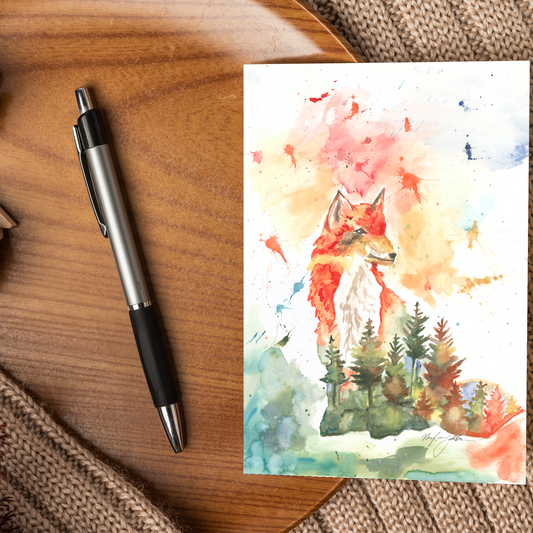 Flat cardstock note card featuring original watercolor piece Forest Fox displayed on a wooden surface beside a black and silver pen.
