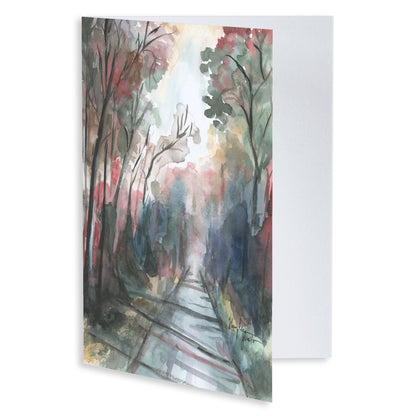 Folding cardstock greeting card featuring original watercolor piece Forest Road slightly open to display the empty inside.