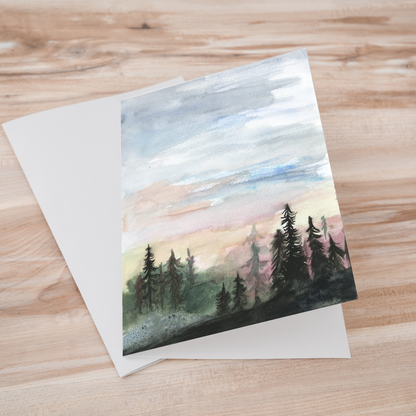 Folding cardstock greeting card featuring original watercolor piece Forest Skyline laying one on top of another.