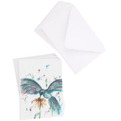 A stack of flat cardstock note cards featuring original watercolor piece Hovering Hummingbird next to a stack of the matching euro flap envelopes.