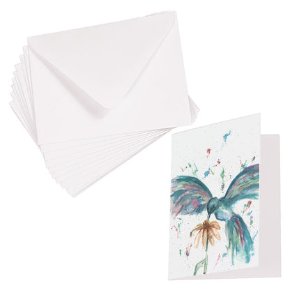 Folding cardstock greeting card featuring original watercolor piece Hovering Hummingbird laying next to a stack of euro flap envelopes.