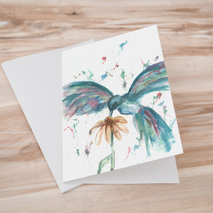 Folding cardstock greeting card featuring original watercolor piece Hovering Hummingbird laying one on top of another.