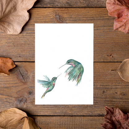 Flat cardstock note card featuring original watercolor piece Hummingbird Duel styled on rustic wooden boards with dried autumn leaves.