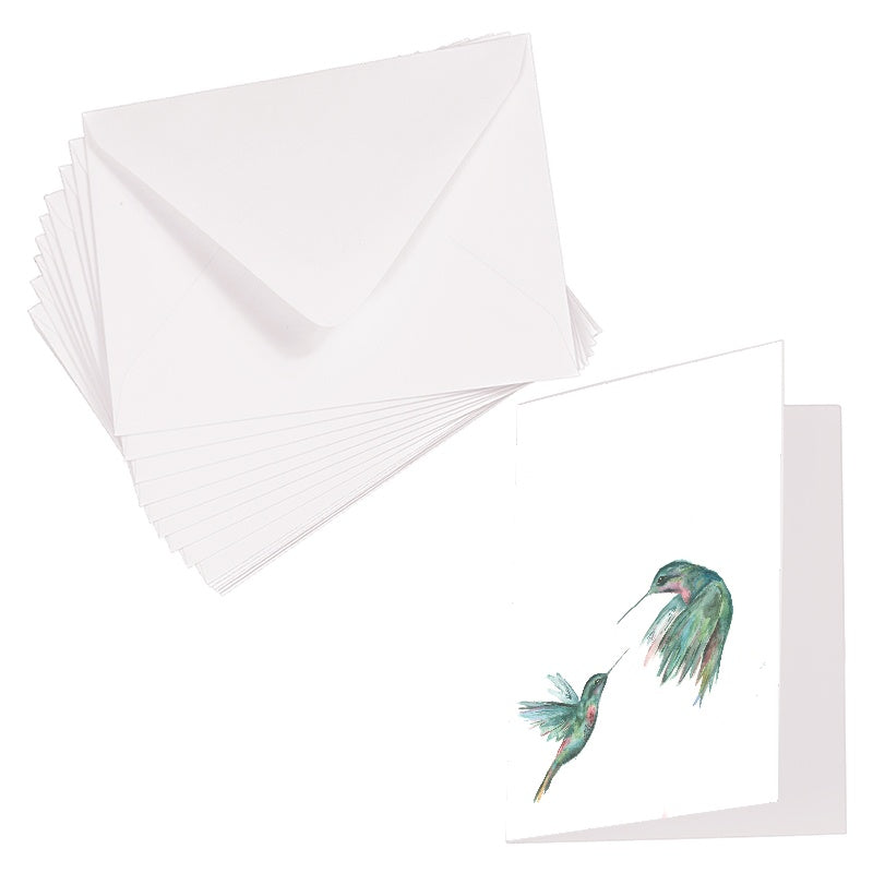 Folding cardstock greeting card featuring original watercolor piece Hummingbird Duel laying next to a stack of euro flap envelopes.