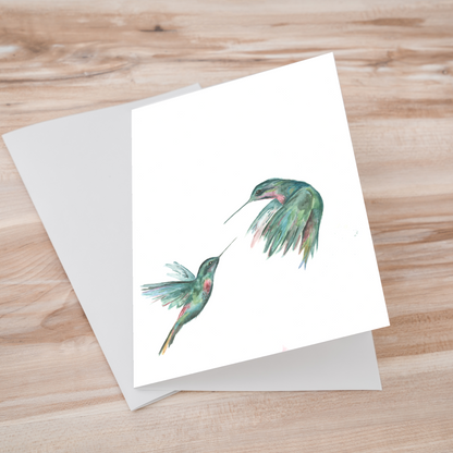 Folding cardstock greeting card featuring original watercolor piece Hummingbird Duel laying one on top of another.