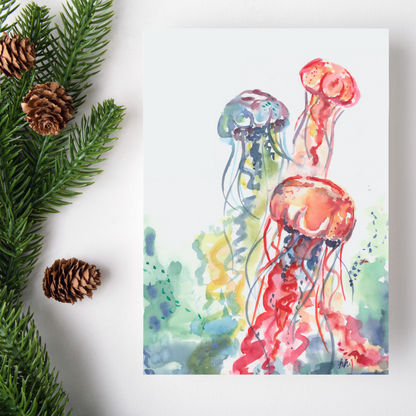 Flat cardstock note card featuring original watercolor piece Jellyfish Bloom on a white background. Green pine fronds with brown pinecones decorate the left side.