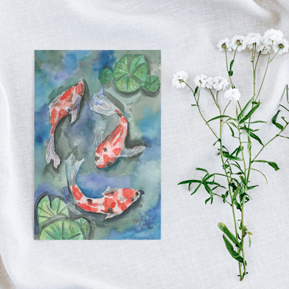 Flat cardstock note card featuring original watercolor piece Koi Pond on a white linen background next to fresh white flowers.