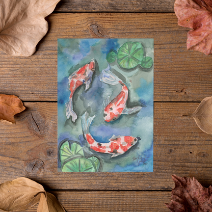 Flat cardstock note card featuring original watercolor piece Koi Pond styled on rustic wooden boards with dried autumn leaves.
