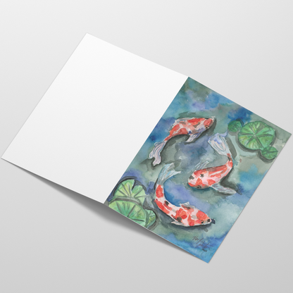 Folding cardstock greeting card featuring original watercolor piece Koi Pond laying open in a table with the outside facing up.