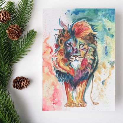 Flat cardstock note card featuring original watercolor piece Lion of Judah on a white background. Green pine fronds with brown pinecones decorate the left side.