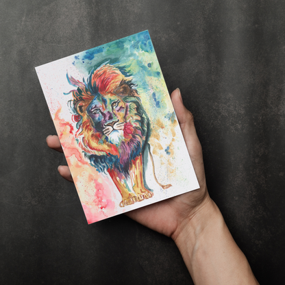 Flat cardstock note card featuring original watercolor piece Lion of Judah in a person's right hand. The background transitions from black at the bottom to a dull gray at the top.