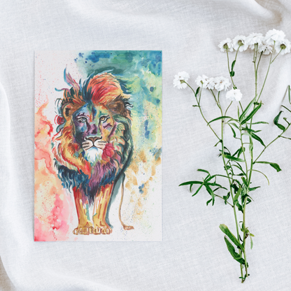 Flat cardstock note card featuring original watercolor piece Lion of Judah on a white linen background next to fresh white flowers.