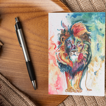Flat cardstock note card featuring original watercolor piece Lion of Judah displayed on a wooden surface beside a black and silver pen.