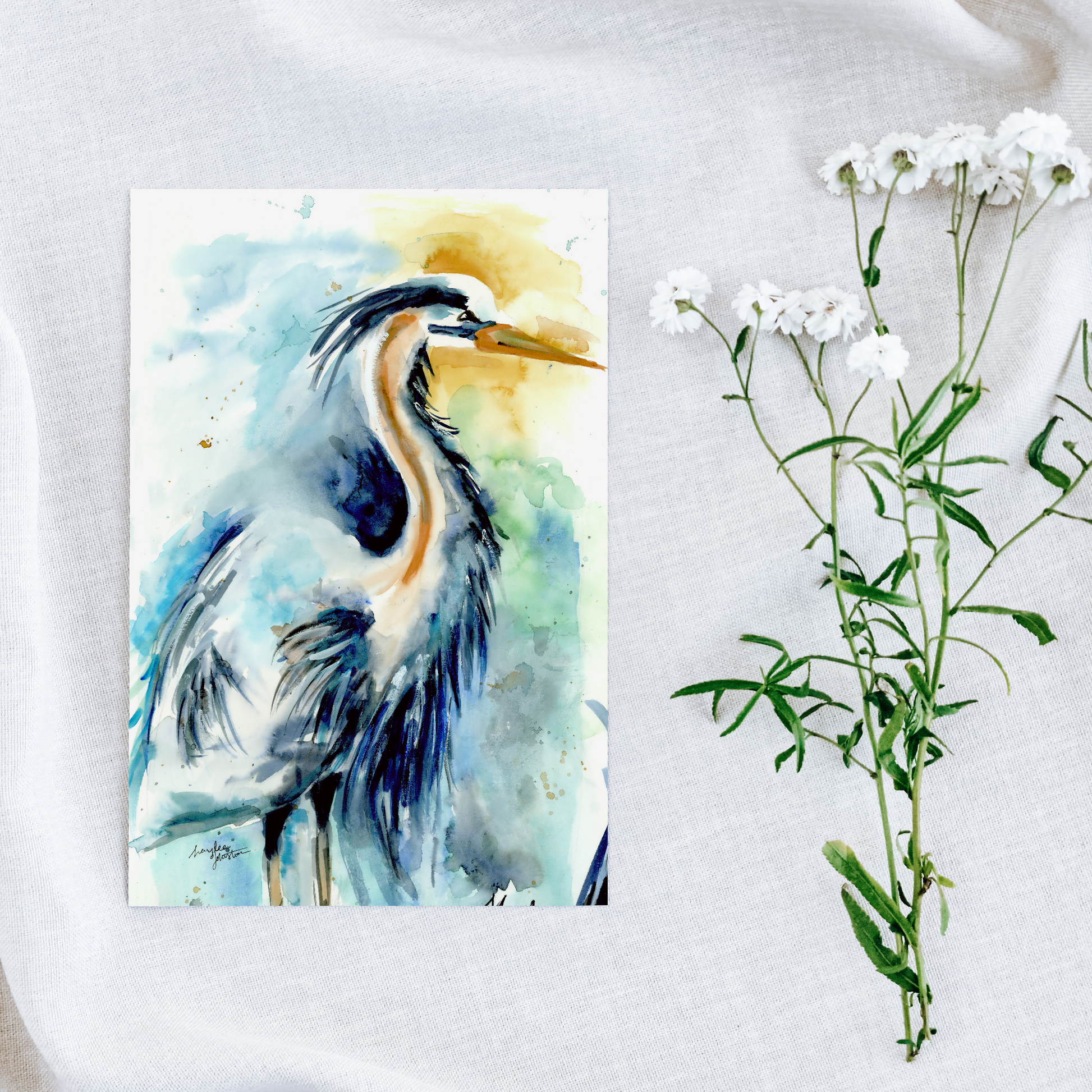 Flat cardstock note card featuring original watercolor piece Male Heron on a white linen background next to fresh white flowers.