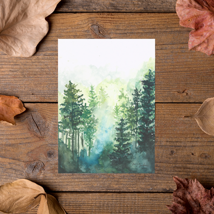 Flat cardstock note card featuring original watercolor piece Morning Forest styled on rustic wooden boards with dried autumn leaves.