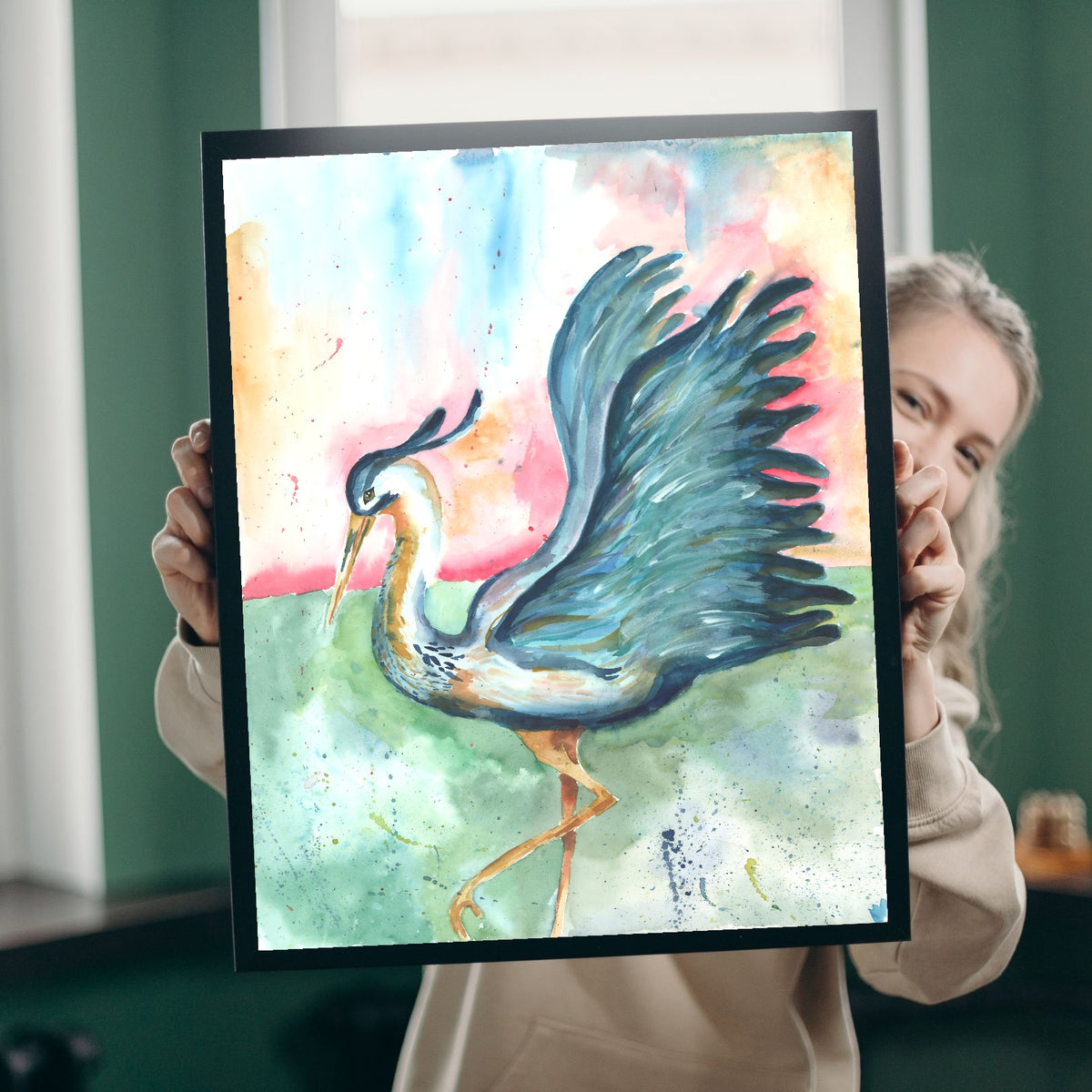 A smiling woman with blonde hair peeks out from behind Giclée Morning Glories, holding it up in a black frame in a room with green walls and bright windows, giving a sense of the print's real-life scale.