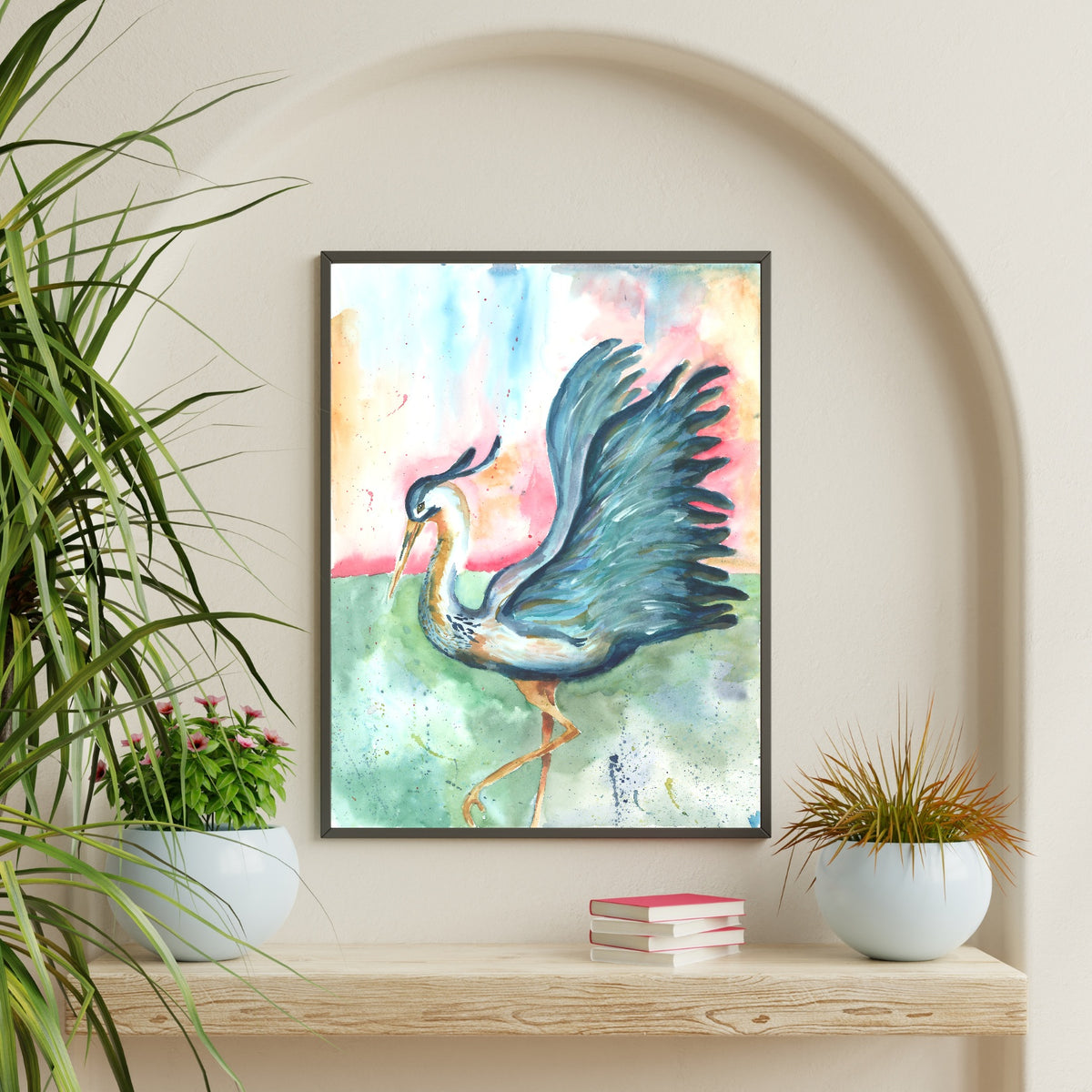 Giclée Morning Glories in a thin black frame hangs inside an arched alcove on a cream wall, above a chunky light wood shelf styled with a stack of pink books and two round white pots holding green and bronze plants.