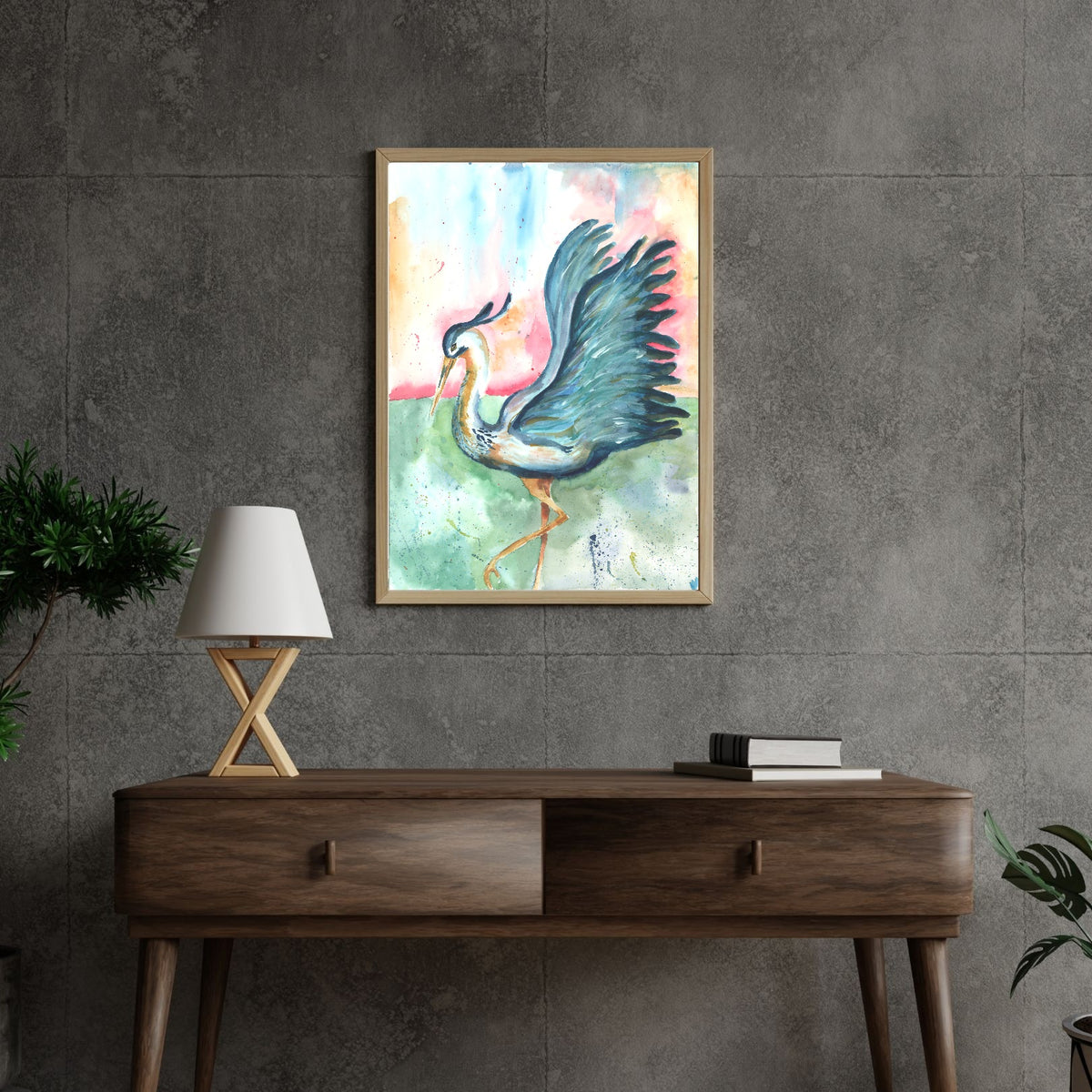 Giclée Morning Glories in a light wood frame hangs on a gray concrete tile wall above a dark walnut mid-century console table. A white lamp with crossed wooden legs and a stack of books sit on the console, with green plants at the edges of the scene.