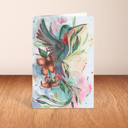 Folding cardstock greeting card featuring original watercolor piece Queen of Flight standing upright on a wooden table.