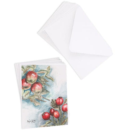 A stack of flat cardstock note cards featuring original watercolor piece Red Apples and Rosehips next to a stack of the matching euro flap envelopes.