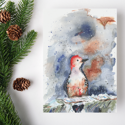 Flat cardstock note card featuring original watercolor piece Red Bellied Woodpecker on a white background. Green pine fronds with brown pinecones decorate the left side.