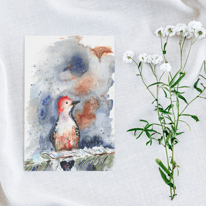 Flat cardstock note card featuring original watercolor piece Red Bellied Woodpecker on a white linen background next to fresh white flowers.
