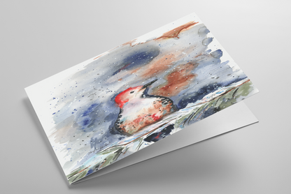 Folding greeting card featuring original watercolor piece Red Bellied Woodpecker laying down showing cardstock thickness and blank inside.