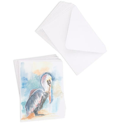 A stack of flat cardstock note cards featuring original watercolor piece Shy Pelican next to a stack of the matching euro flap envelopes.