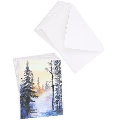 A stack of flat cardstock note cards featuring original watercolor piece Winter Wood next to a stack of the matching euro flap envelopes.