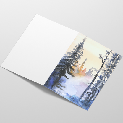 Folding cardstock greeting card featuring original watercolor piece Winter Wood laying open in a table with the outside facing up.