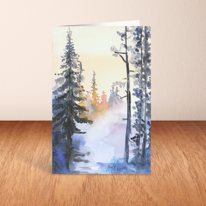 Folding cardstock greeting card featuring original watercolor piece Winter Wood standing upright on a wooden table.